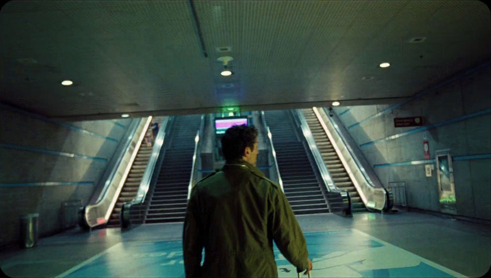 a man is walking down an escalator in a building