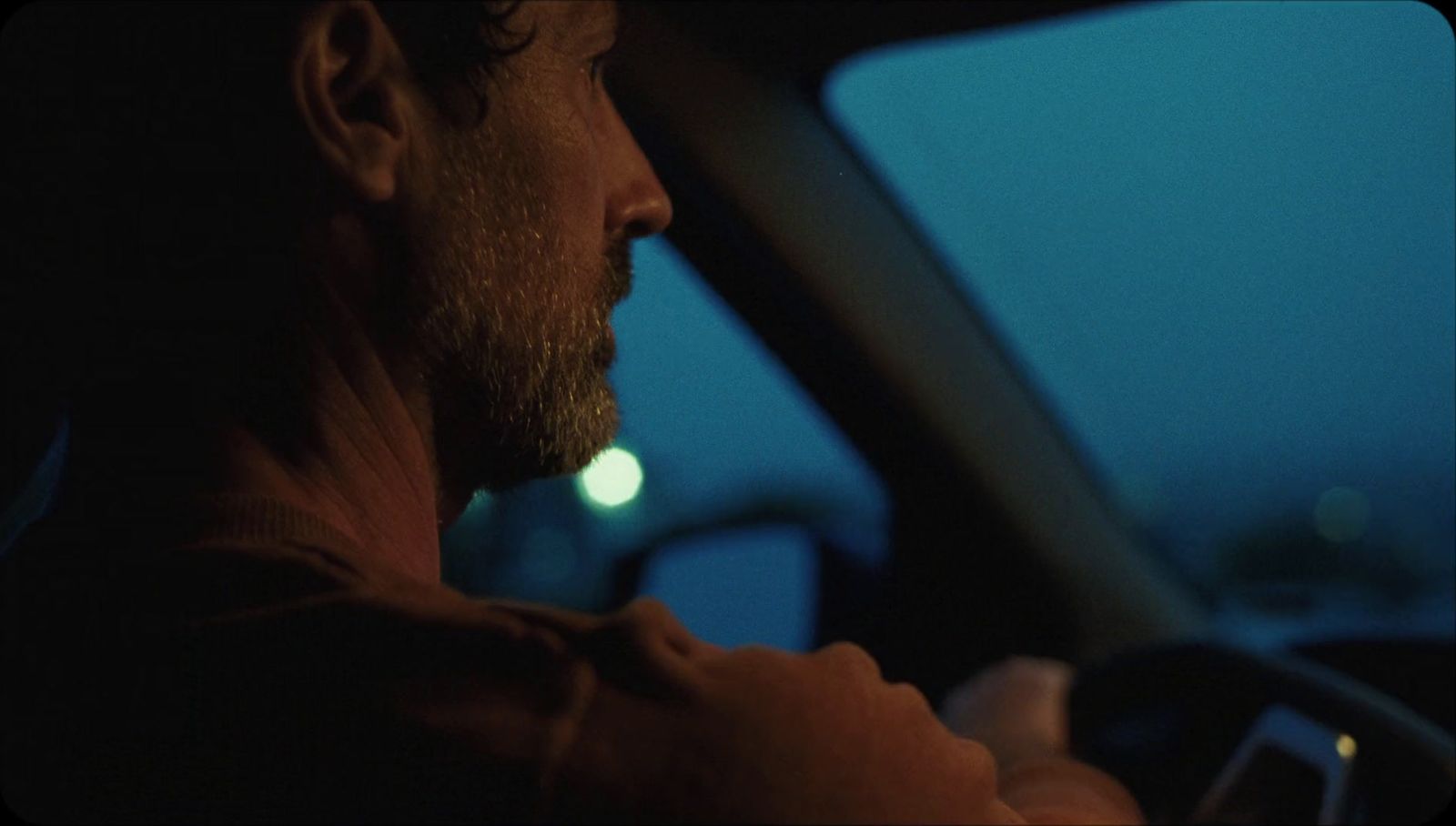 a man driving a car at night in the dark