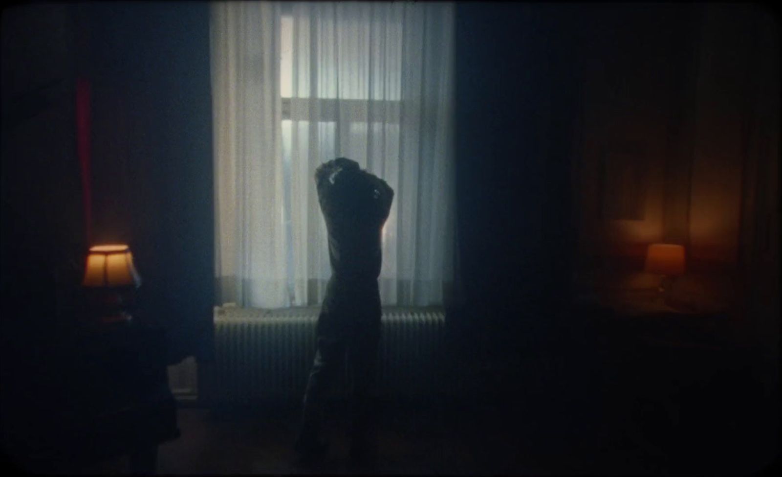 a person standing in front of a window in a dark room