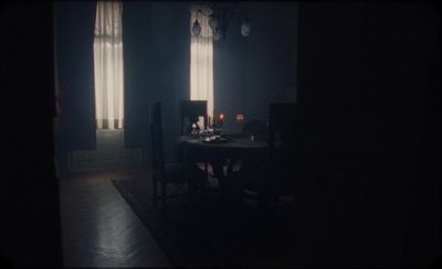 a dark room with a table and chairs