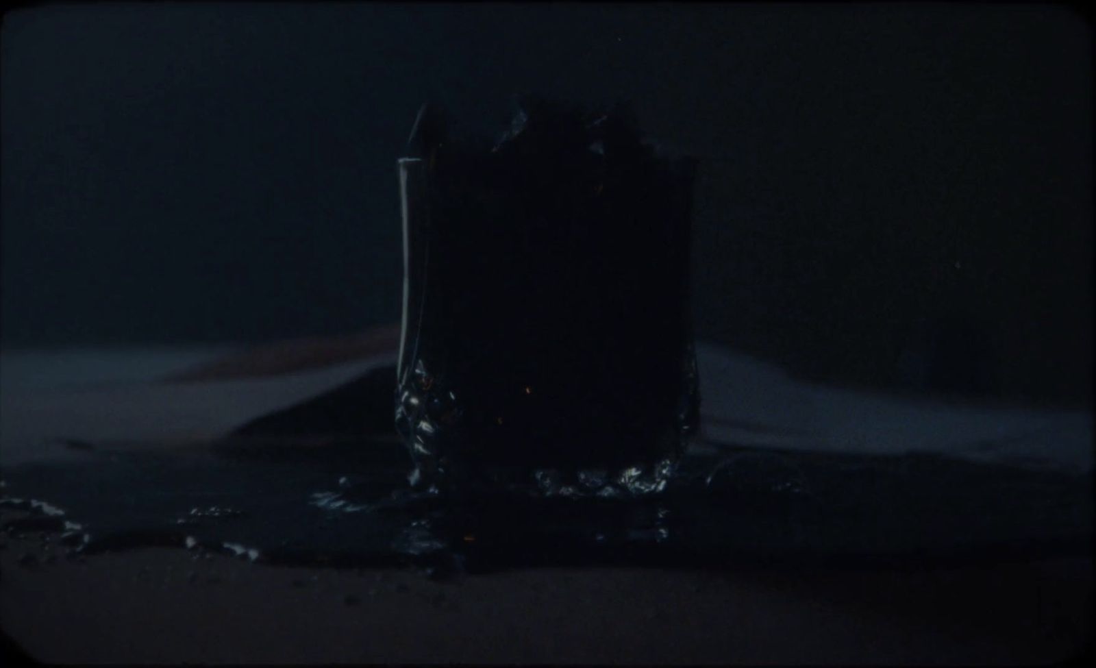 a pair of boots sitting on top of a bed in the dark