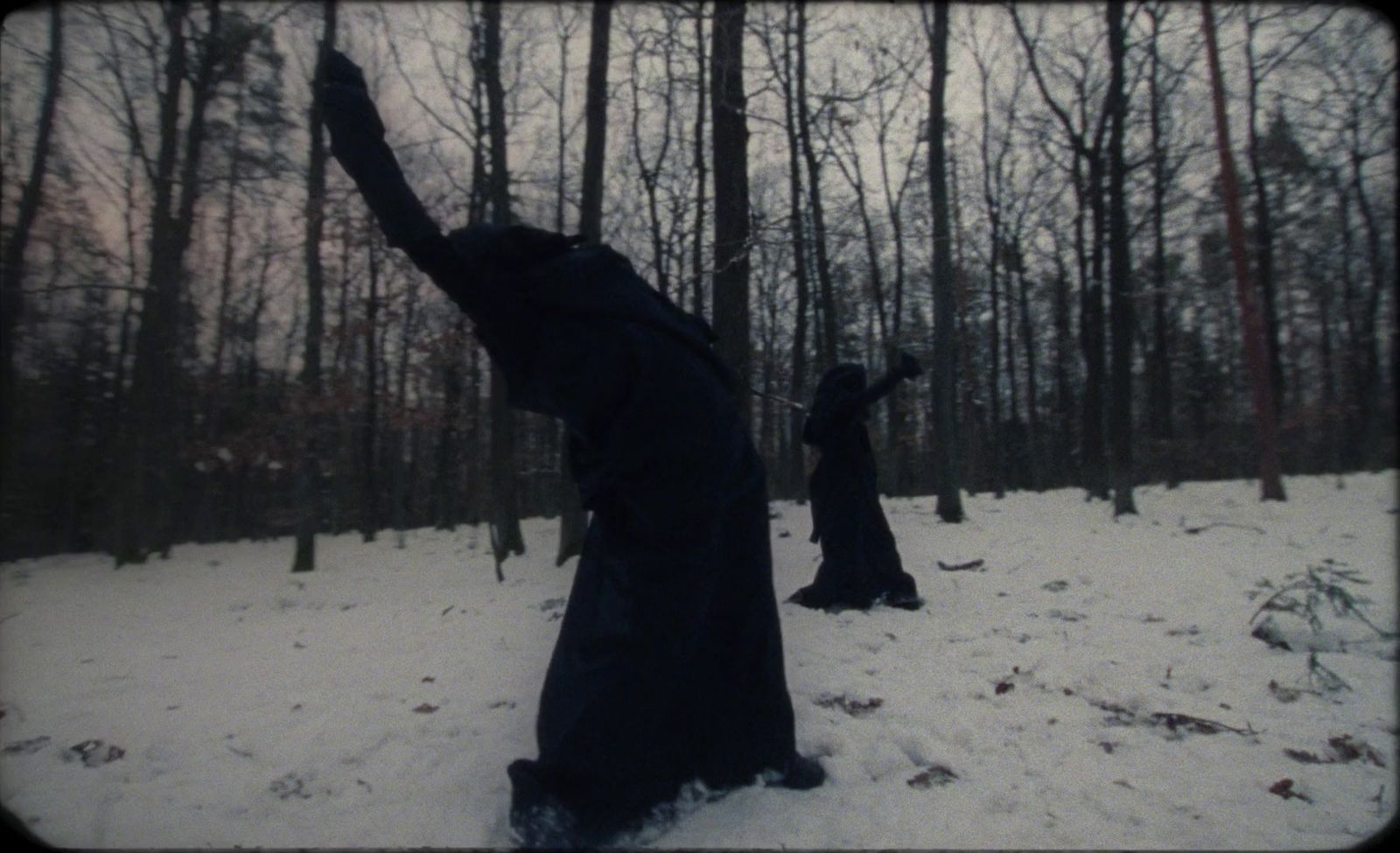 two people standing in the snow with their arms in the air