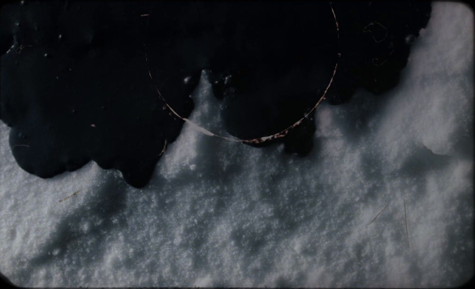 a snow covered ground with a circular object in the middle of it