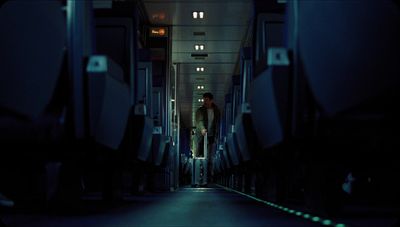 a man walking down a hallway in a train