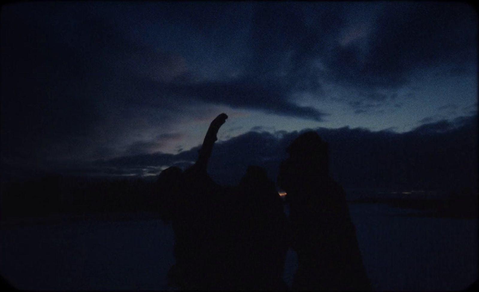 a couple of people that are standing in the dark