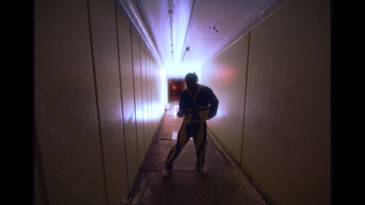 a man standing in a long narrow hallway