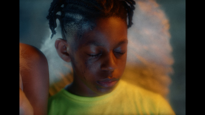 a young girl with dreadlocks looking at a cell phone