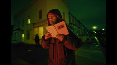 a man standing on a street holding a piece of paper