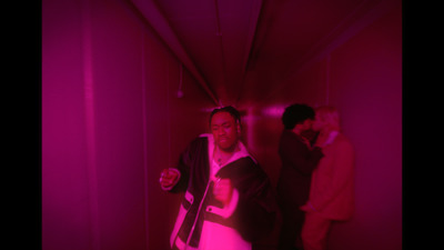 a man standing in a room with a pink light