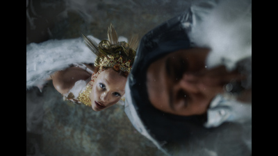 a young girl wearing a headdress is reflected in a mirror