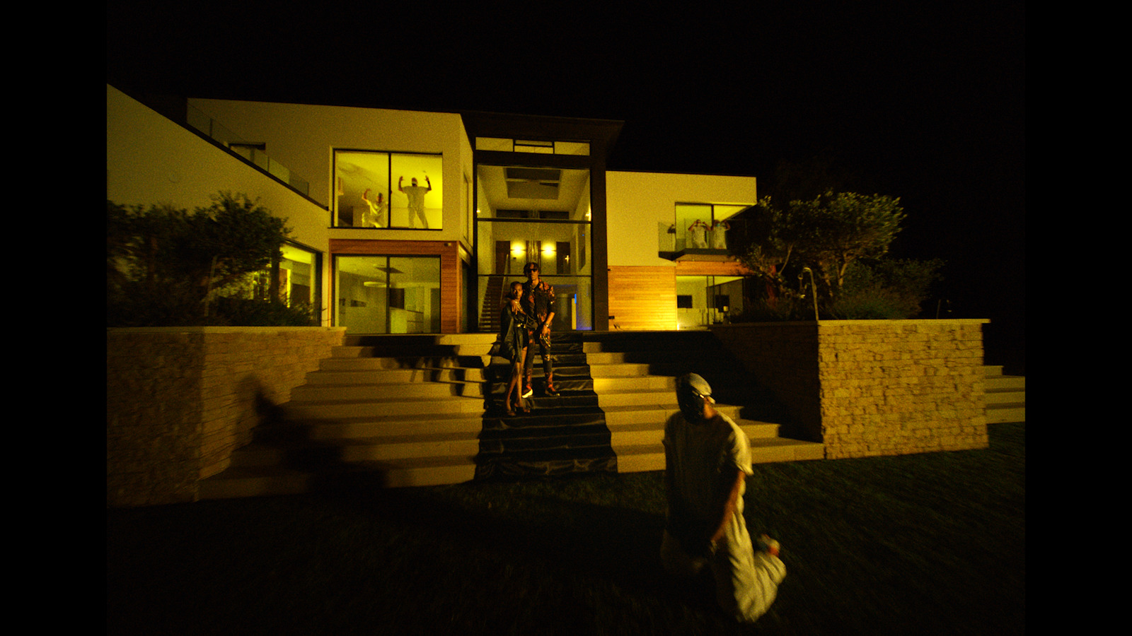 a man and a woman standing in front of a house at night