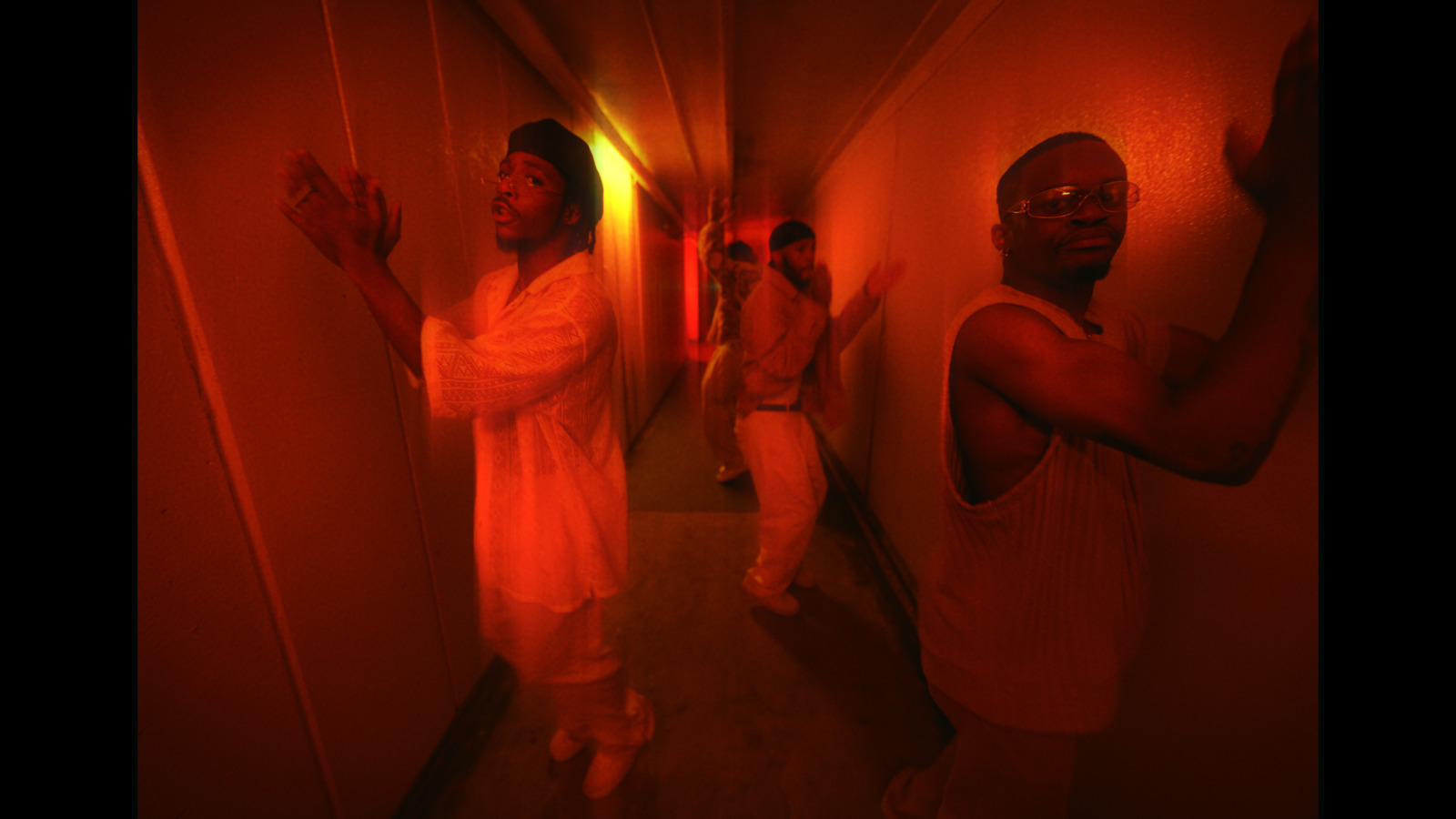 a group of men standing in a hallway next to each other