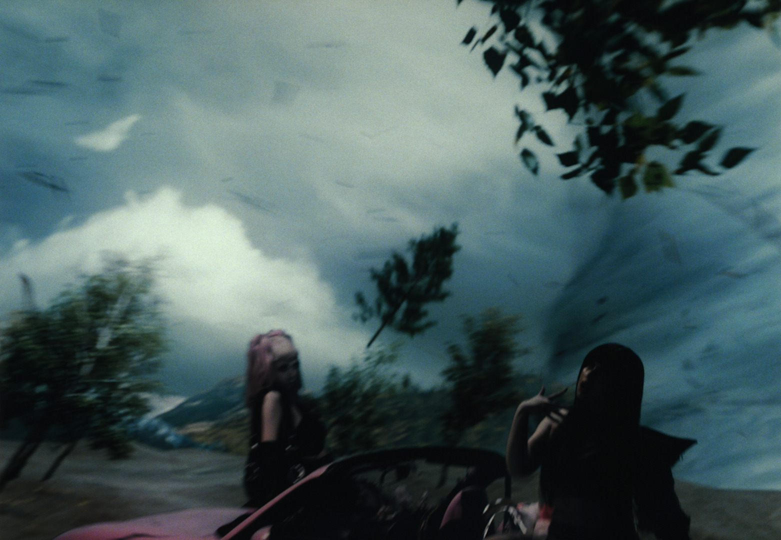 a woman standing in front of a red car