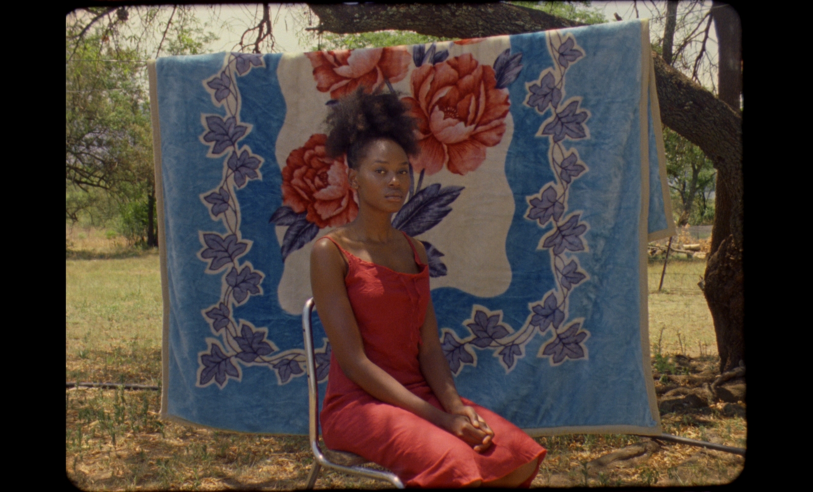 a woman sitting on a chair in front of a quilt