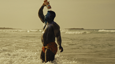 a man standing in the ocean holding a surfboard