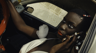 a woman sitting in a car talking on a cell phone