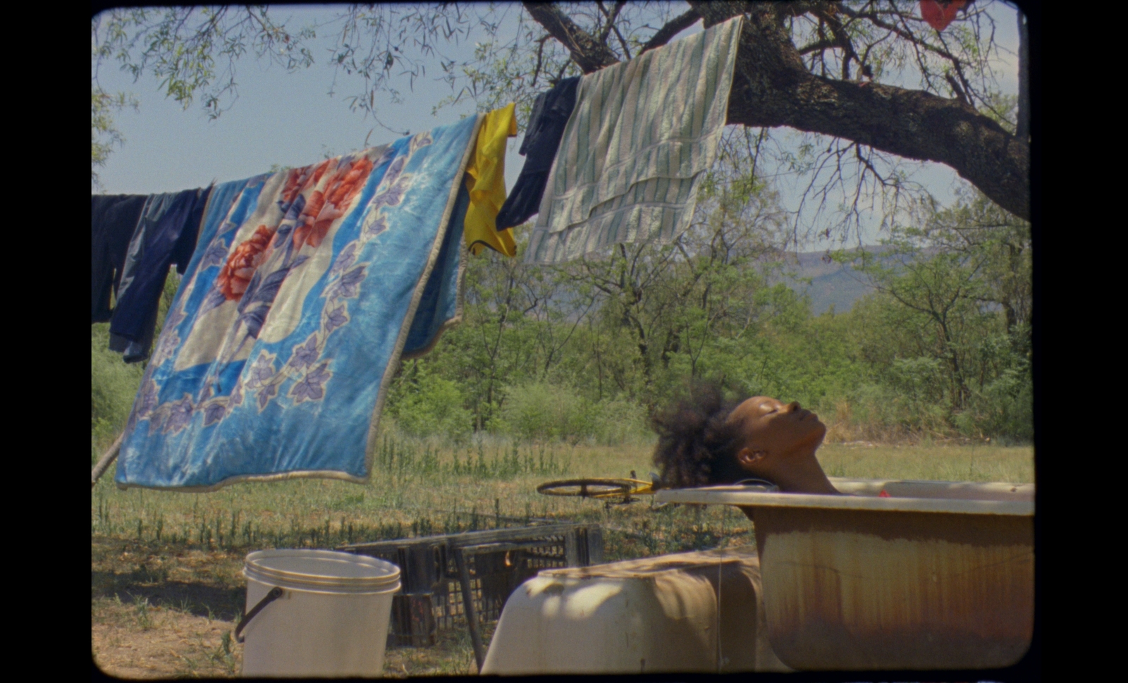 a woman taking a bath in a tub under a tree