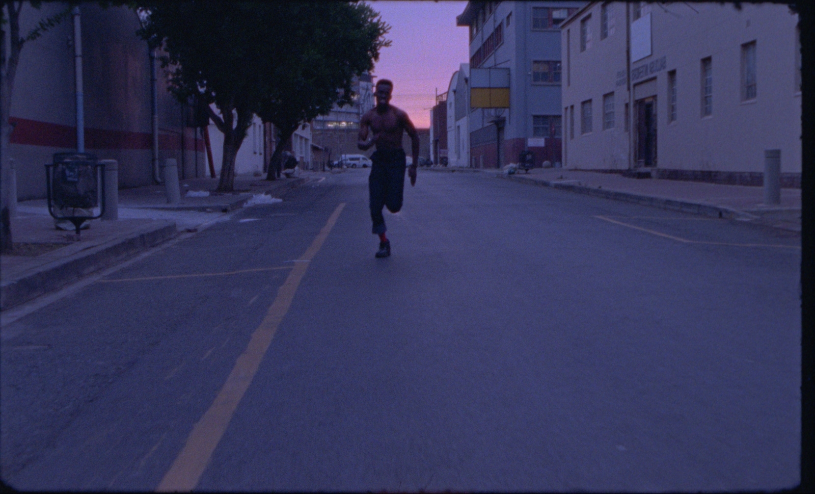 a man riding a skateboard down a street next to tall buildings