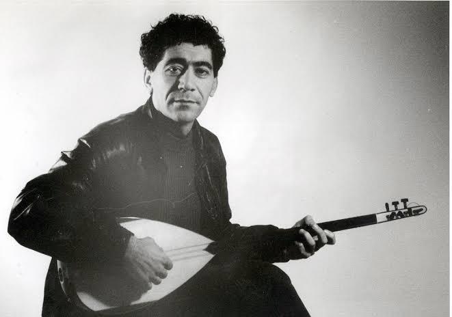 a black and white photo of a man holding a guitar