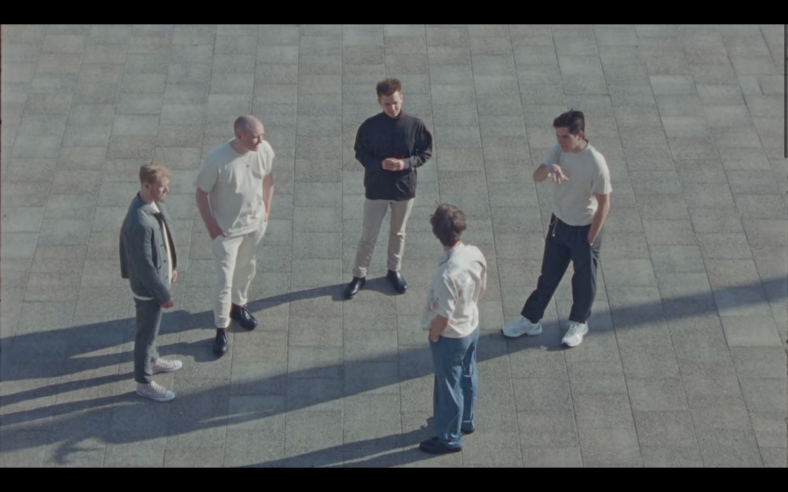 a group of men standing around talking to each other