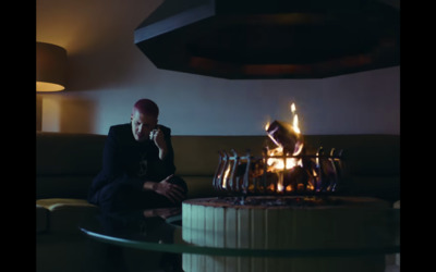 a man sitting on a couch next to a fire place