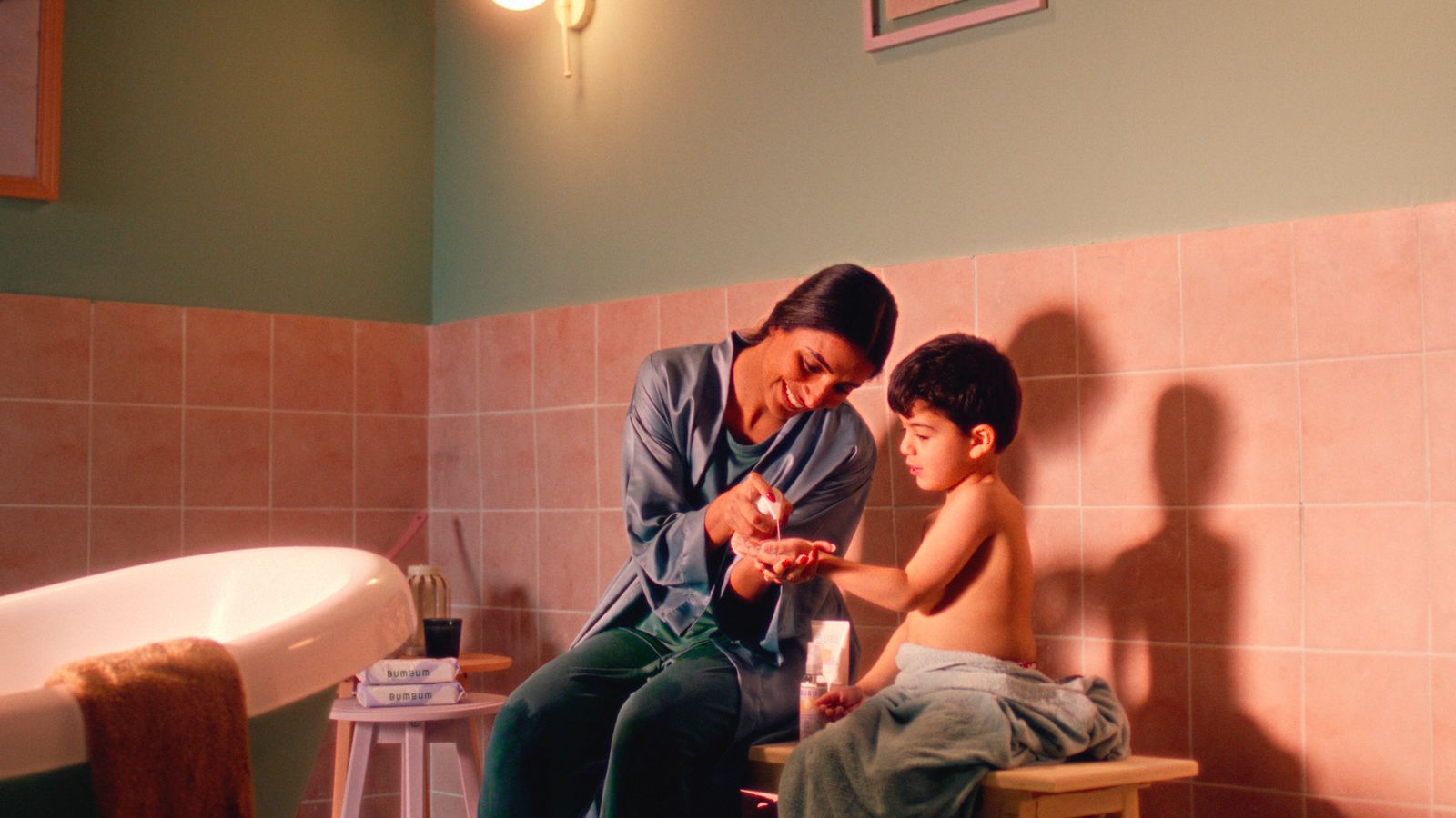 a woman sitting next to a child in a bathroom