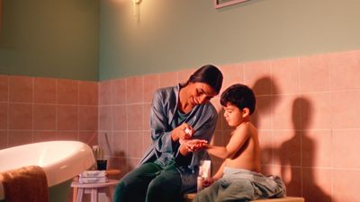 a woman sitting next to a child in a bathroom