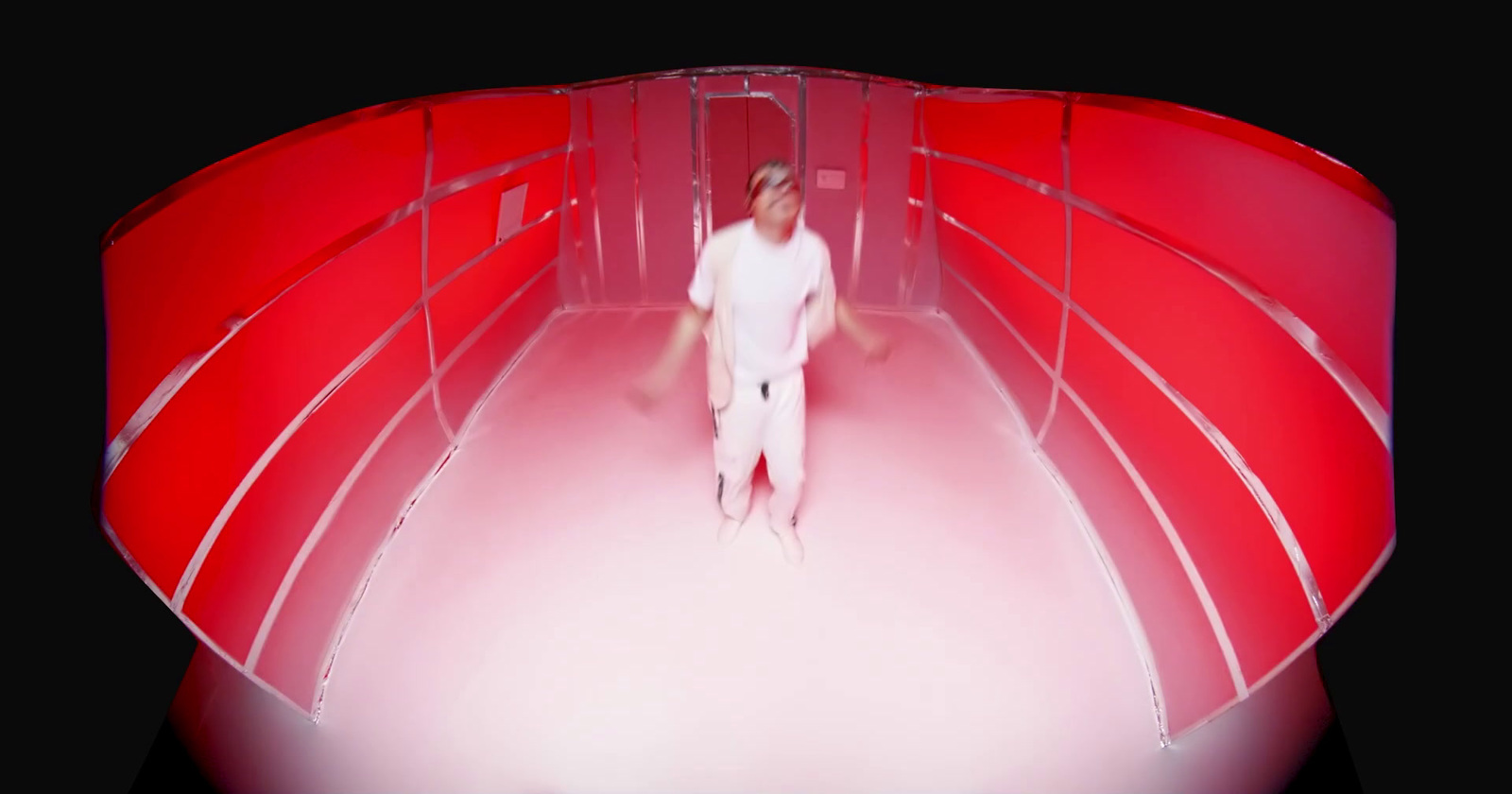 a man standing in front of a red wall