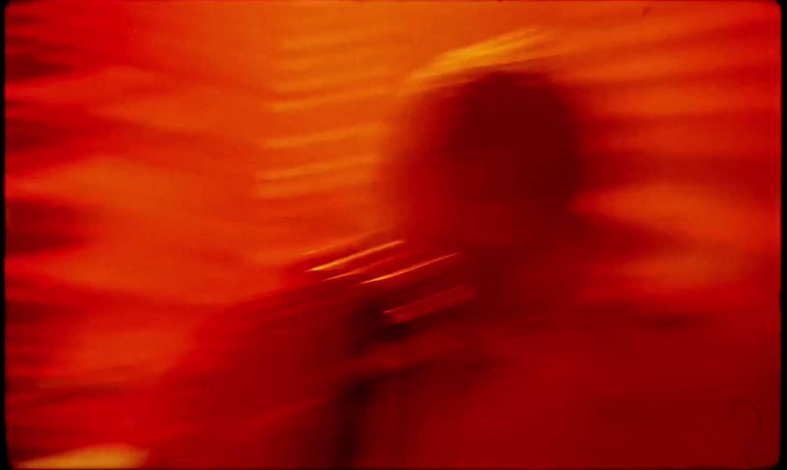 a blurry image of a person standing in front of a red wall