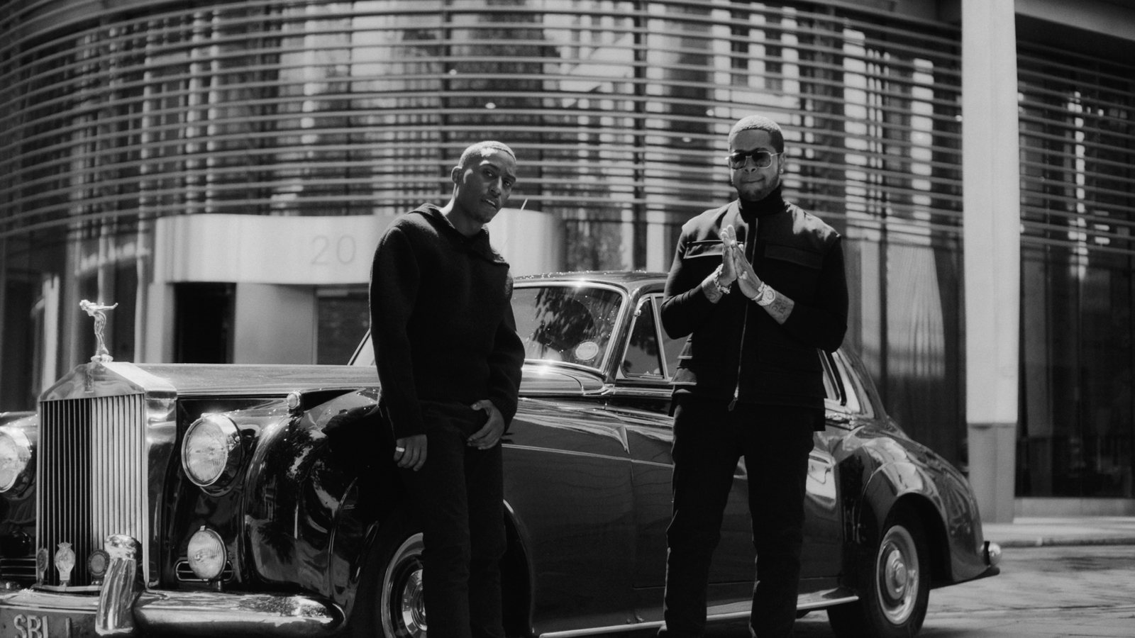 a couple of men standing next to a car