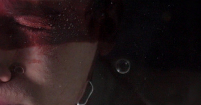 a woman with red hair and piercings looking in a mirror