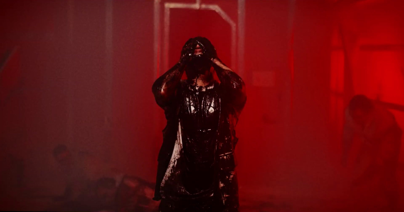 a woman in a black leather outfit standing in a red room