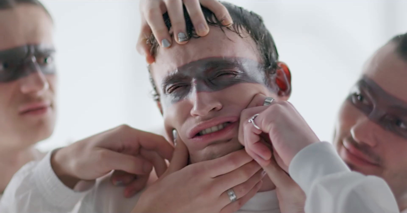 a man is putting on a woman's face