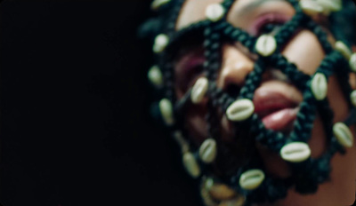 a close up of a woman's face with beads on her head