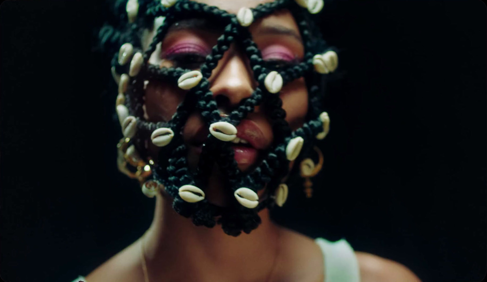 a woman wearing a mask made of shells