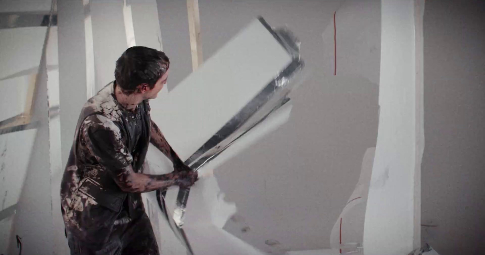 a man holding a large pair of scissors in a room