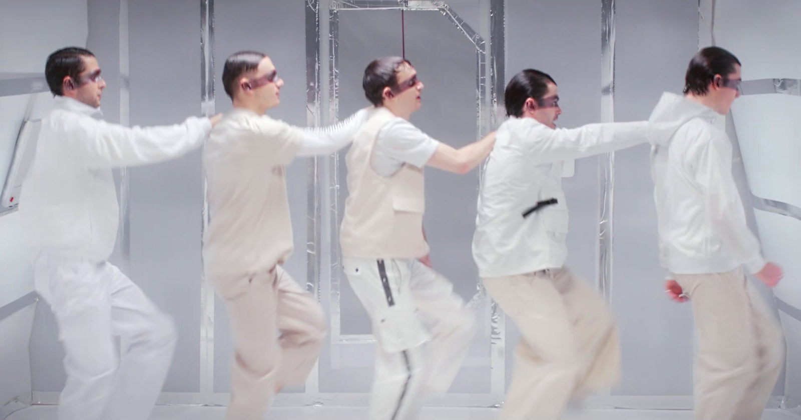 a group of young men dancing in front of a mirror