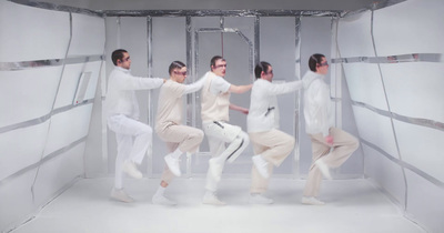 a group of men dancing in a white room