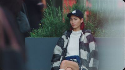 a woman with red hair sitting on a bench