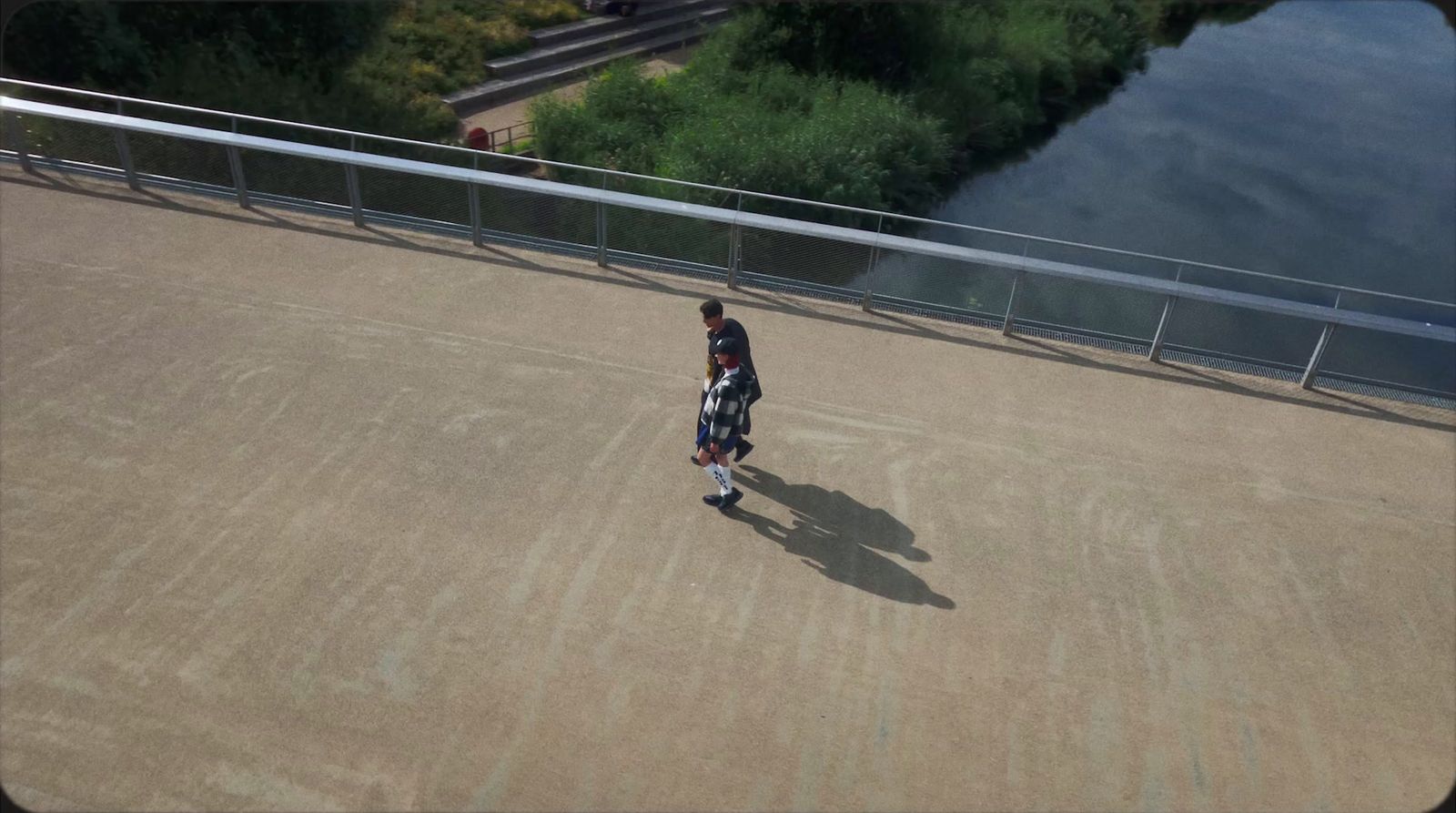 a man walking across a bridge over a river