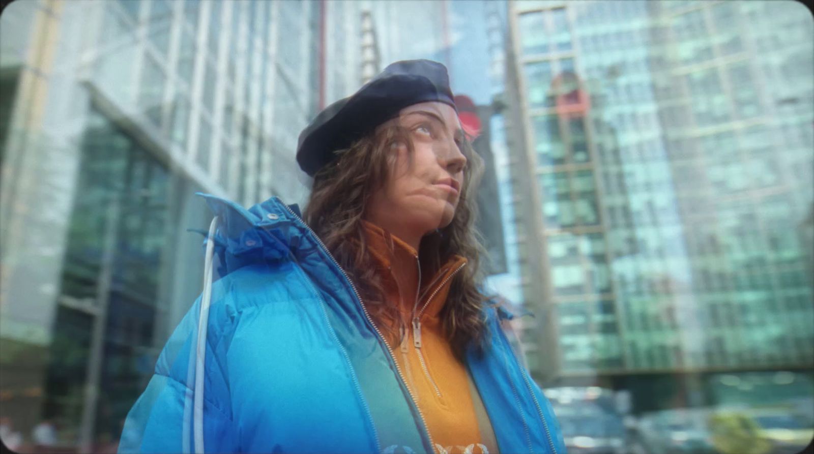 a man with long hair wearing a blue jacket and hat