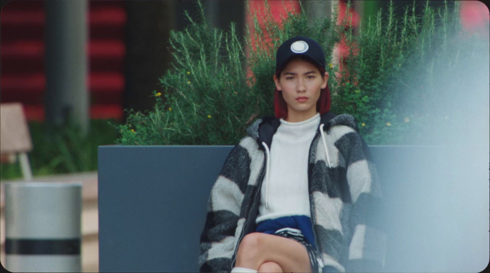 a person sitting on a bench with a hat on