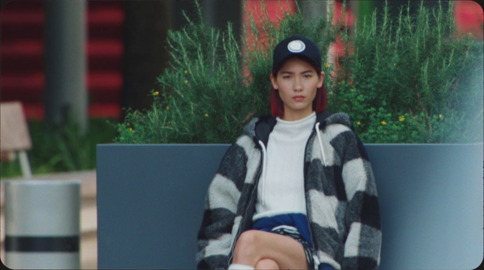 a person sitting on a bench with a hat on