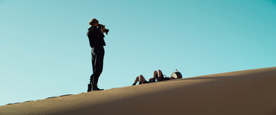 a person standing on top of a sand dune