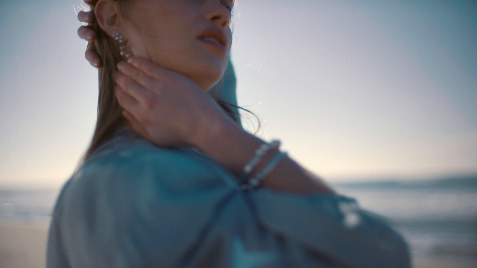 a woman in a blue dress is standing on the beach