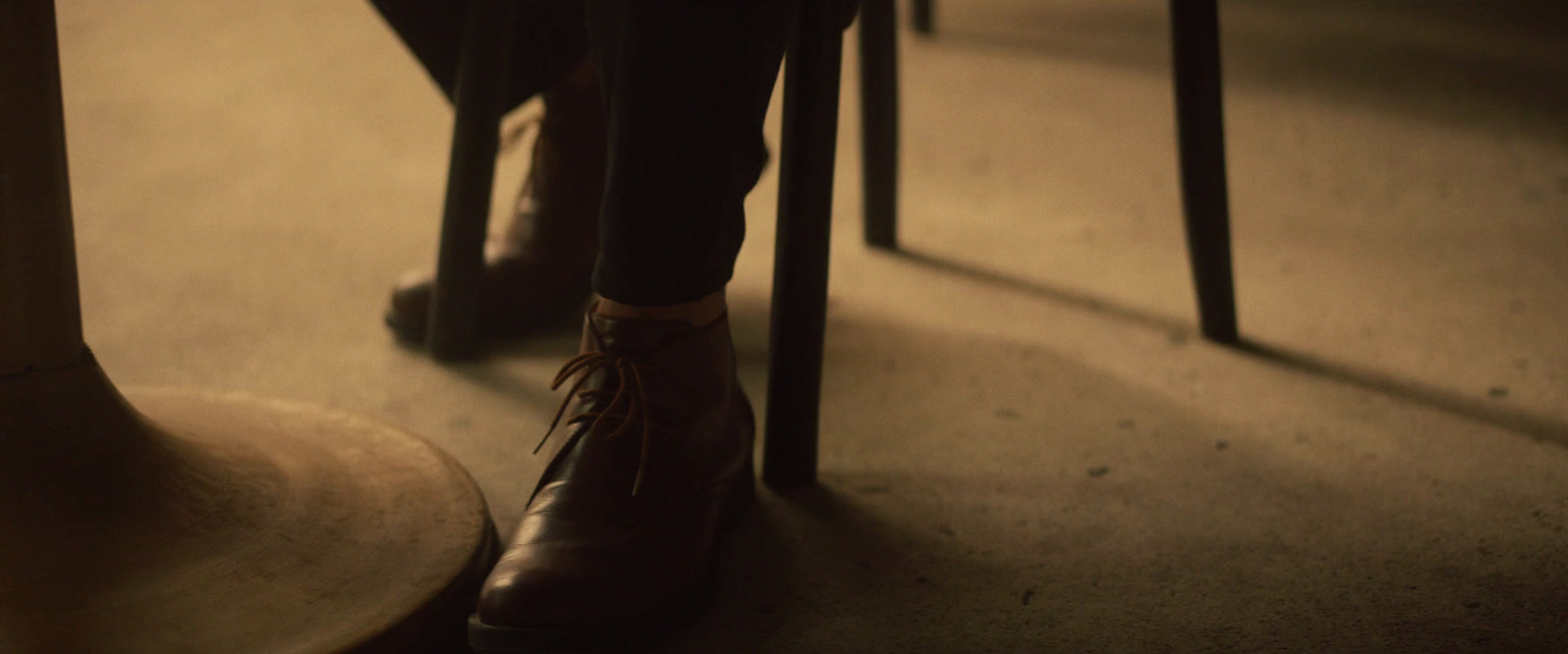 a person sitting at a table with a pair of shoes