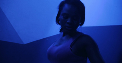 a woman standing in a dark room holding a cell phone