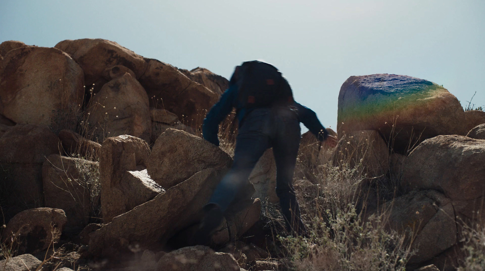 a person with a backpack climbing up a mountain