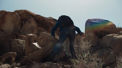 a person with a backpack climbing up a mountain