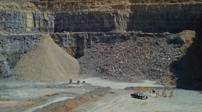 a car is parked in front of a large quarry